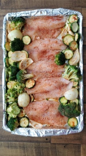 prepping healthy sheet pan tilapia with vegetables