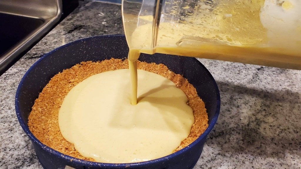 Pouring Mango Peach Pie Filling into the Crust