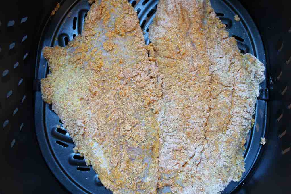 Air frying the crispy catfish fillets.