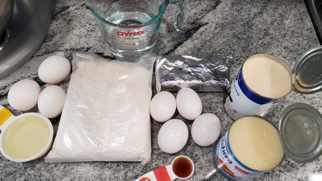 The ingredients needed to make flancocho are cake mix, eggs, cream cheese, sweetened condensed milk, evaporated milk and vanilla extract.