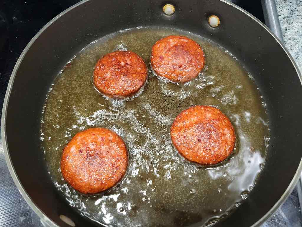 Frying the salami in canola oil.