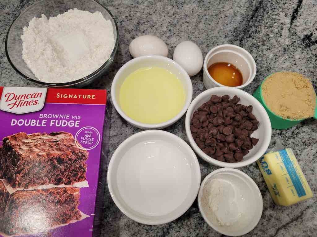 The ingredients needed are brownie mix, eggs, oil, water, brown sugar, flour, butter, baking powder, salt, vanilla extract and chocolate chips.