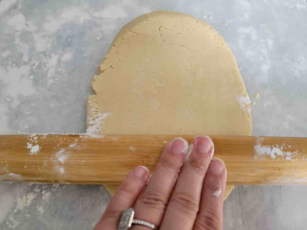 Use a rolling pin to roll the dough out about a 1/4 of an inch thick as shown in this picture.
