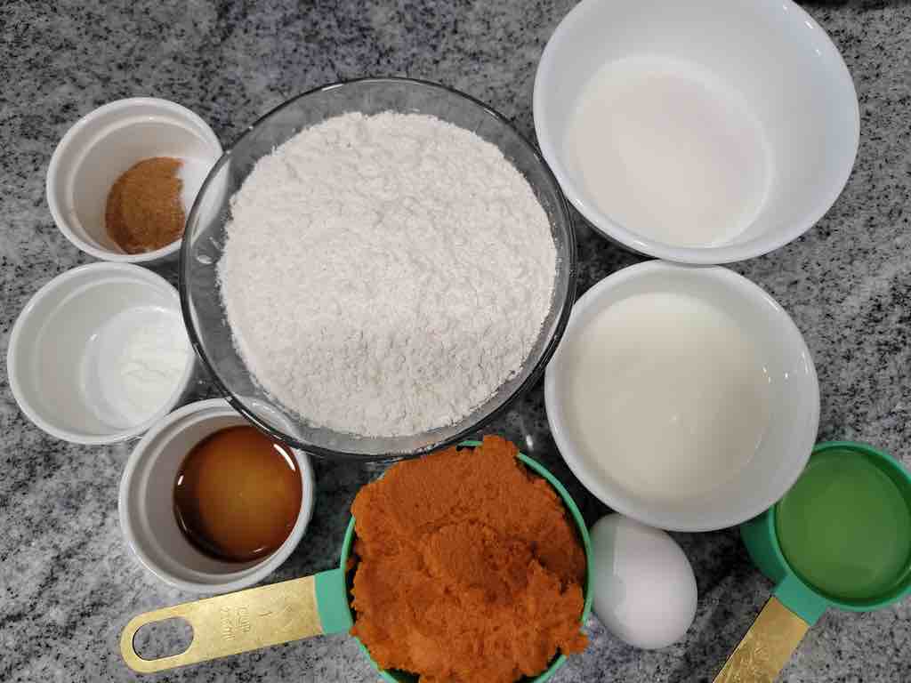 The ingredients needed are flour, baking powder, salt, sugar, pumpkin pie spice, oil, milk, pumpkin puree, egg and vanilla extract.