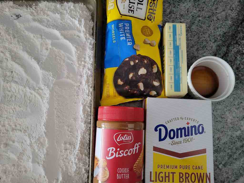 The ingredients needed are flour, cookie butter, butter, vanilla extract, milk, sugar, salt and white chocolate chips.