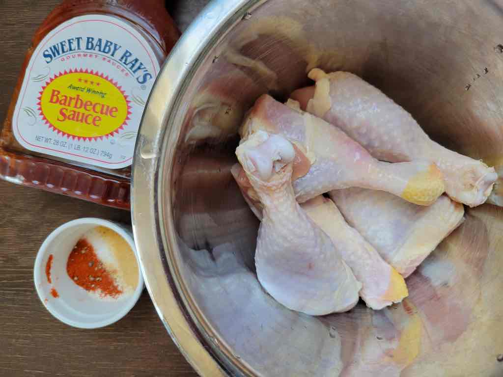 The ingredients needed for this recipe are chicken drumsticks, barbecue sauce, salt, pepper, paprika, granulated garlic, oregano, cayenne pepper and onion powder as shown in this photo.