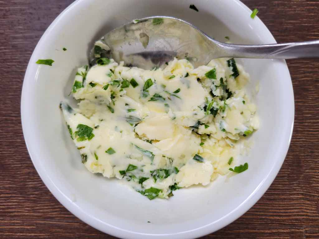 Mix together the softened butter, minced garlic and fresh herbs to make the homemade garlic herb butter as shown in this photo.