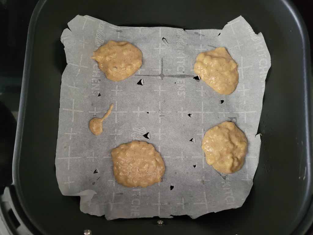 Transfer the batter to a parchment paper lined air fryer using a cookie scoop as shown in this photo.