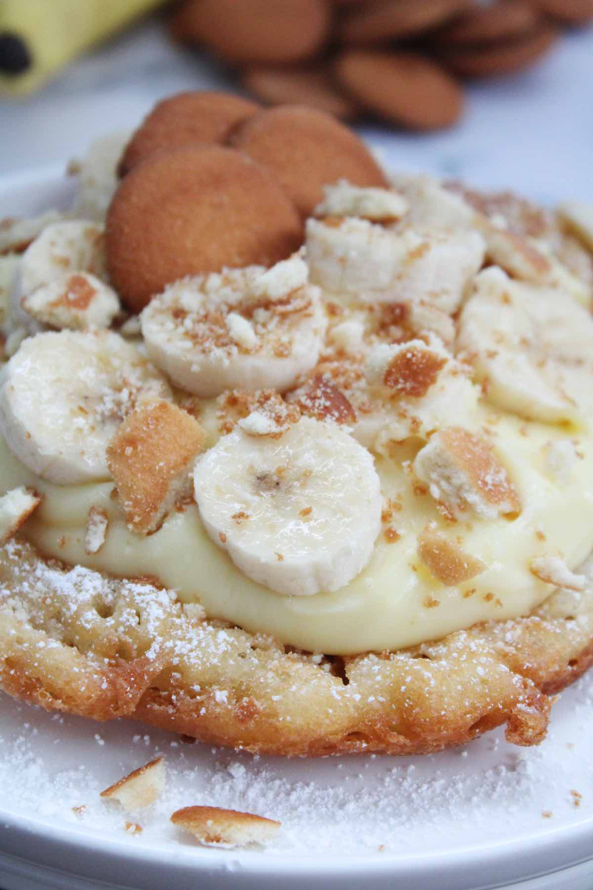 These banana pudding funnel cakes are not your average state food recipe. They're made with bisquick mix and topped with banana pudding, Nilla wafers and fresh bananas.