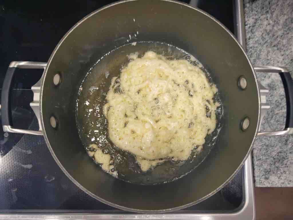 Use a squeeze bottle to drizzle the batter into the hot oil and create that classic funnel cake shape. Fry until golden as shown in this photo.