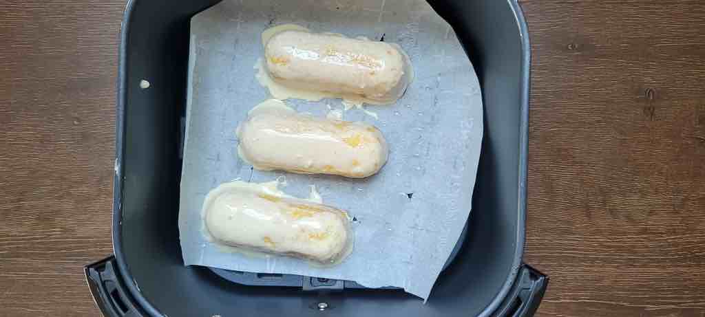 Dip the Twinkies in pancake batter, then transfer to the air fryer to cook as seen in this photo.