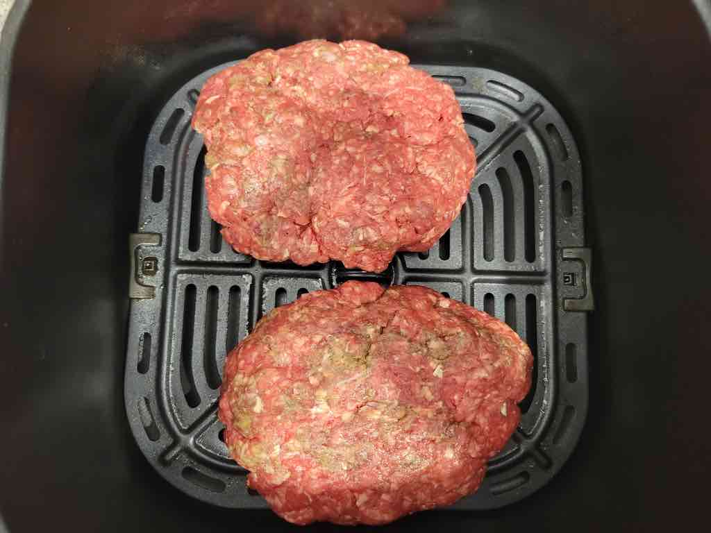 Transfer the ground beef patties to the air fryer to cook in small batches.