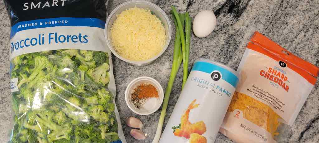 The ingredients needed are broccoli florets, garlic, parmesan cheese, sharp cheddar cheese, panko bread crumbs, paprika powder, cayenne pepper, salt, black pepper, egg and green scallions.
