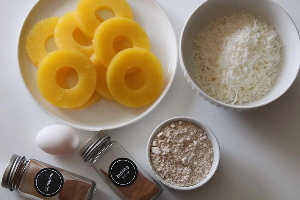 The ingredients needed are pineapple rings, coconut flour and flakes, cinnamon, nutmeg, brown sugar, egg and salt.